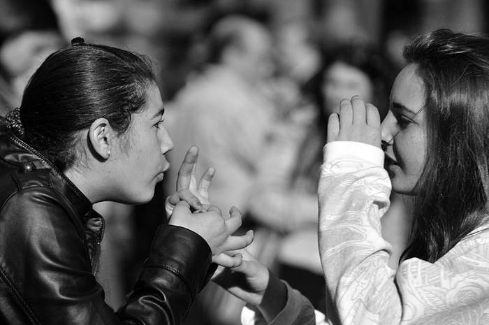 Dos jóvenes hablando lengua de señas, ayer, durante la movilización de sordos. · Foto: Javier Calvelo