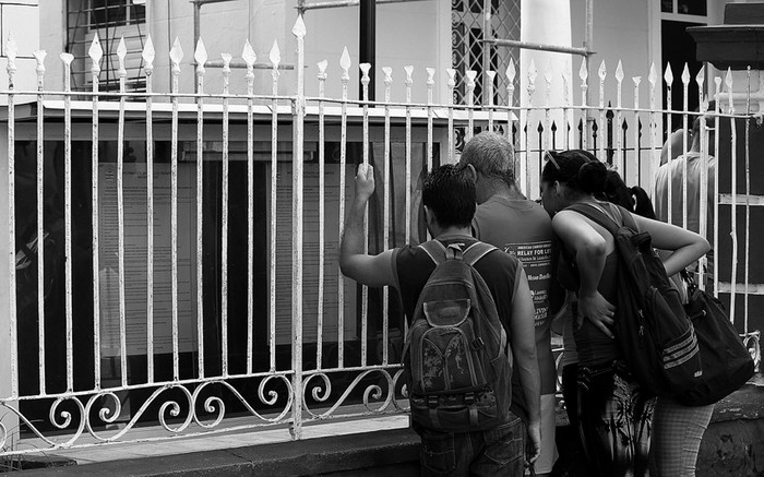 Varias personas leen información sobre trámites migratorios en una oficina regional de la Dirección de Inmigración y Extranjería, en La Habana. / foto: alejandro ernesto, efe · Foto: Alejandro Ernesto, Efe