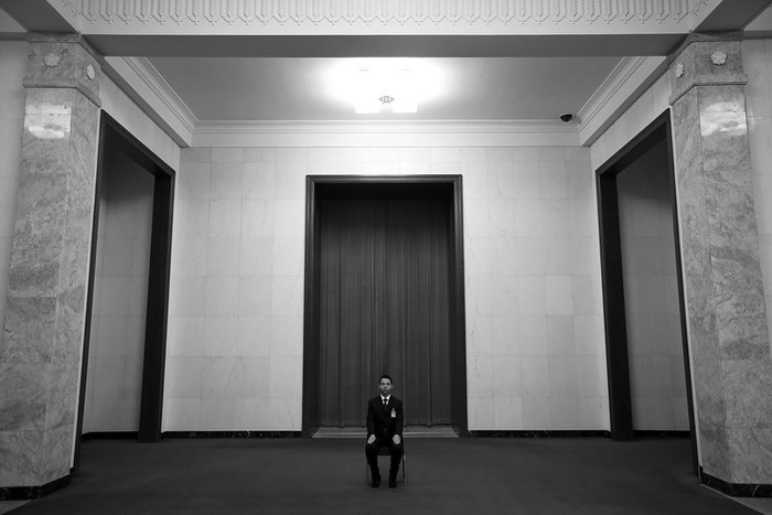 Un miembro del Ejército de la Liberación del Pueblo de China (PLA) sentado en un pasillo del Gran Palacio del Pueblo, antes de una rueda de prensa, en la víspera de la apertura del XVIII Congreso del Partido Comunista de China (PCCh), en Pekín, el miércoles.
 · Foto: Diego Azubel, Efe