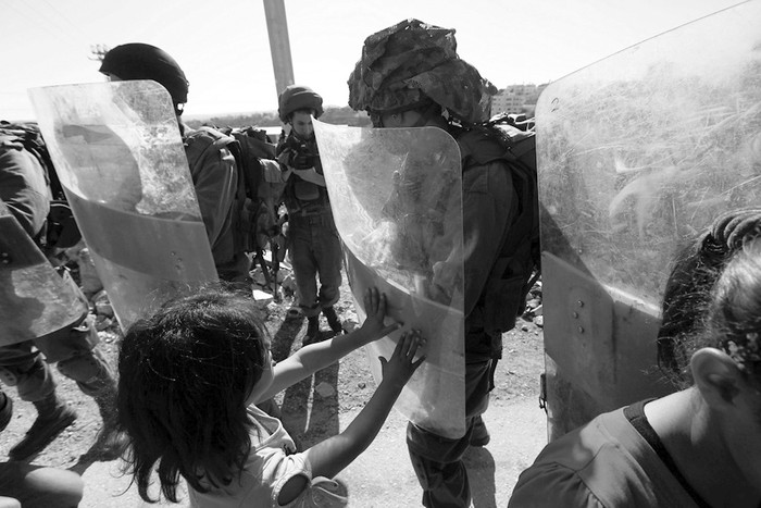 Palestinos y soldados israelíes durante una protesta en el poblado de Al Masara, junto a Belén, en Cisjordania, el viernes. · Foto: Abed Al Hashlamoun, Efe