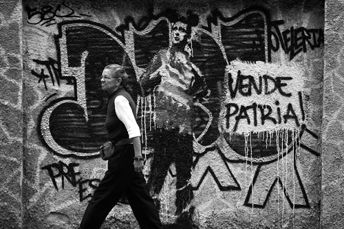 Una mujer camina frente a una pared pintada con un grafitti alusivo al líder opositor venezolano, Henrique Capriles, en Caracas.  · Foto: Miguel Gutierrez, Efe