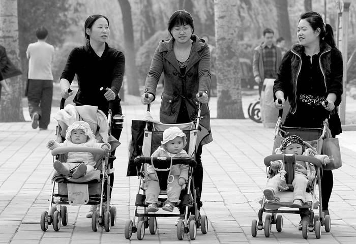 Madres paseando a sus hijos en un parque de Pekín. Foto: Frederic J Brown, Afp