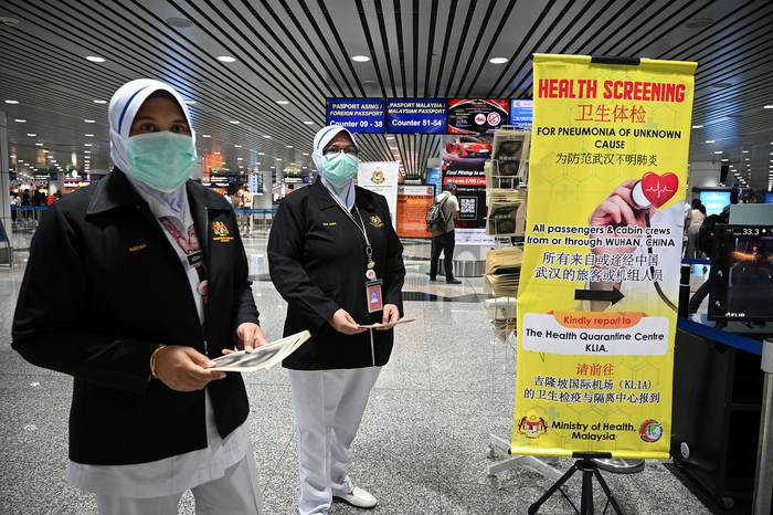Agentes de salud de Malasia alertan sobre el coronavirus, ayer, en el aeropuerto internacional de Kuala Lumpur.

 · Foto: Mohd Rasfan, AFP