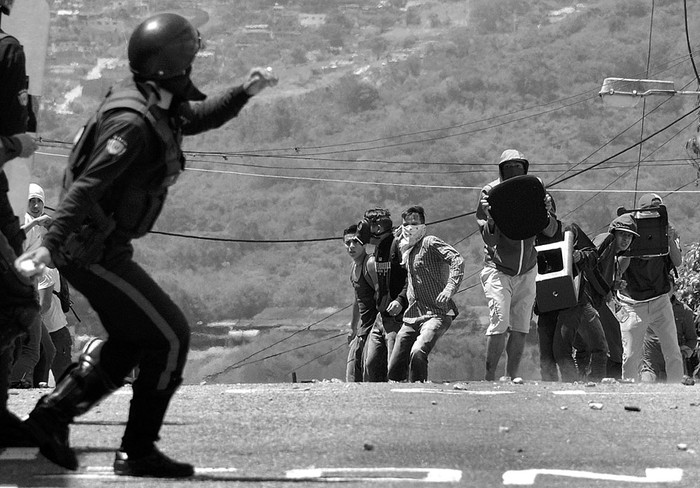 Policías antidisturbios y estudiantes se enfrentan, ayer, en San Cristóbal, Venezuela. Foto: Jorge Castellanos, AFP