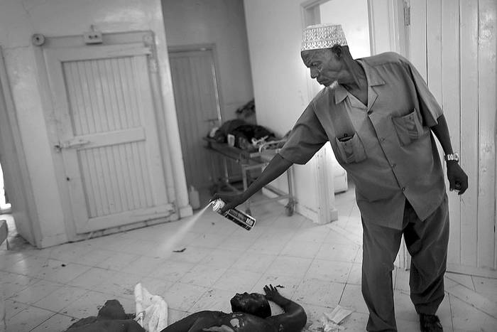 Un empleado de la morgue rocía los cadáveres de presuntos terroristas muertos, el sábado, en la ciudad de Garissa, Kenia.Foto: Dai Kurokawa, Efe