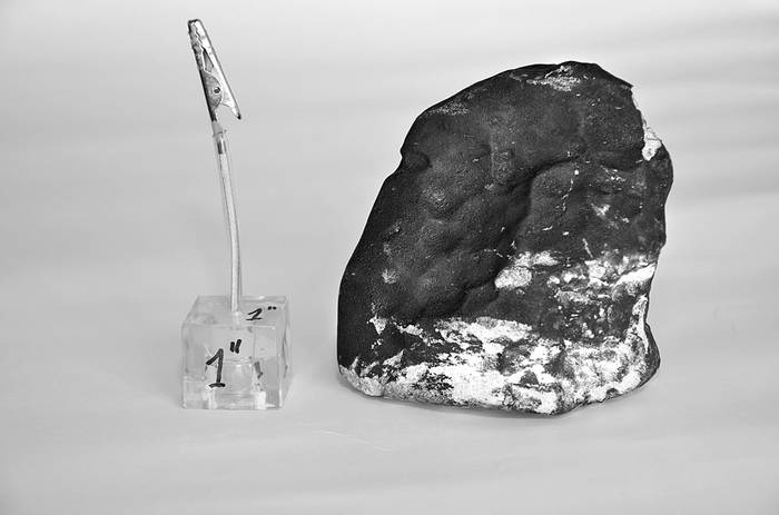 Meteorito caído en San Carlos, Maldonado, junto a una pulgada cúbica de referencia. Foto: Facultad de Ciencias, Difusión