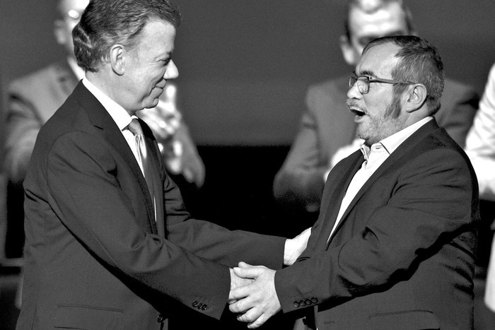 Juan Manuel Santos, presidente colombiano, y Timoleón Jiménez, líder de las FARC, durante la firma del segundo acuerdo de paz, ayer, en el teatro Colón, en Bogotá, Colombia. Foto: Luis Robayo, AFP