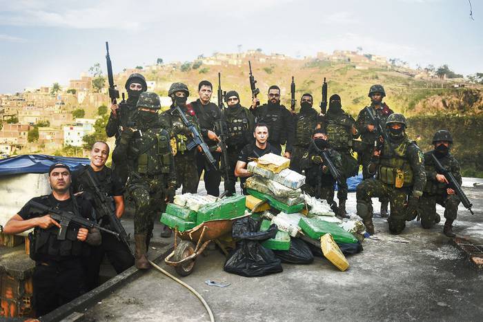 Soldados posando, ayer, después de incautar drogas en la favela Complexa de Alemão, en Río de Janeiro.
 · Foto: Fábio Teixeira