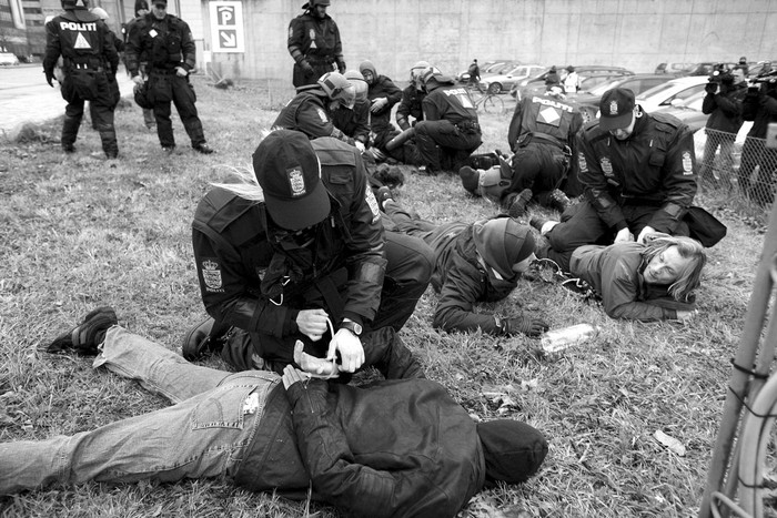 Agentes antidisturbios esposan a varios activistas cerca del centro de convenciones Bella Center, en Copenhague, donde se celebra la Cumbre de la ONU sobre Cambio Climático (COP15) y hacia donde se dirigen miles de activistas con el objetivo de acceder al edificio.  · Foto: Efe, Claus Bech