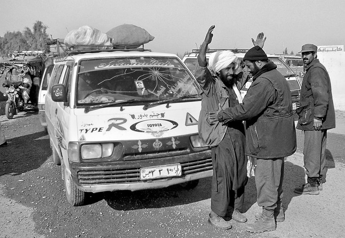 Un policía afgano cachea a un hombre que ha huido del distrito de Marjah, a su llegada a Lashkar Gah, la capital de la provincia de Helmand.  · Foto: EFE, s/d de autor