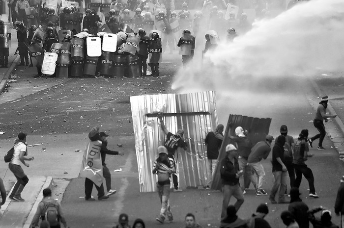 Manifestantes afines al candidato opositor hondureño Salvador Nasralla, de la oposición, durante  enfrentamientos con la Policía cerca del Tribunal Supremo Electoral en Tegucigalpa, Honduras. Foto: Rodrigo Arangua, Afp