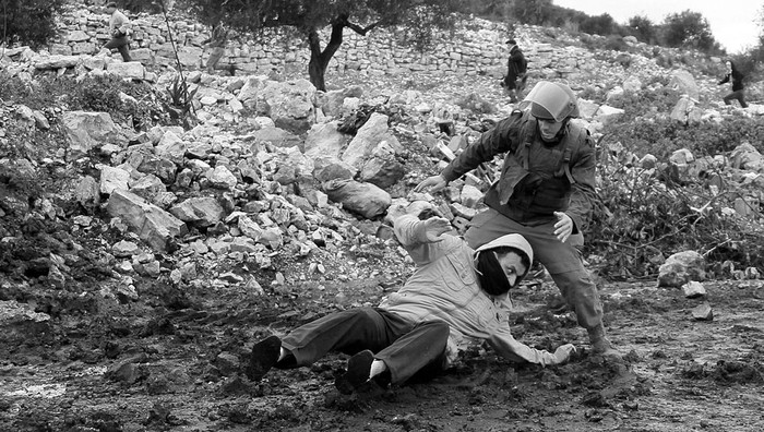 Un palestino es perseguido por un soldado israelí, el viernes, durante una protesta contra los asentamientos judíos en Qadomem,
en la localidad de Kufr Qadom, cerca de Nablus (Cisjordania). Foto: Alaa Badarneh, Efe