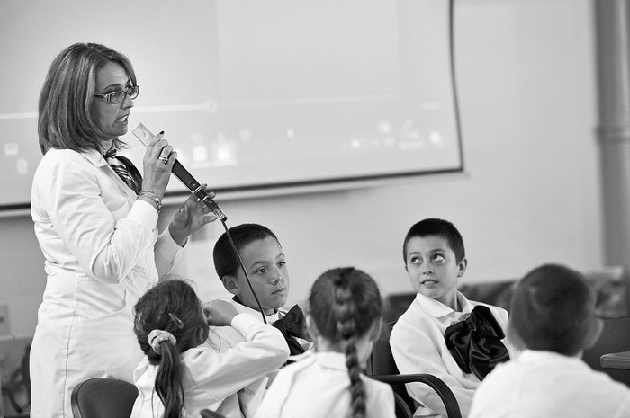 La maestra Walquiria Hernández y sus alumnos de la escuela 68 de Costa de Santa Lucía, el viernes 8 de diciembre, en el 9º Coloquio de Educación Rural, en el salón de actos del CEIP. Foto: Federico Gutiérrez