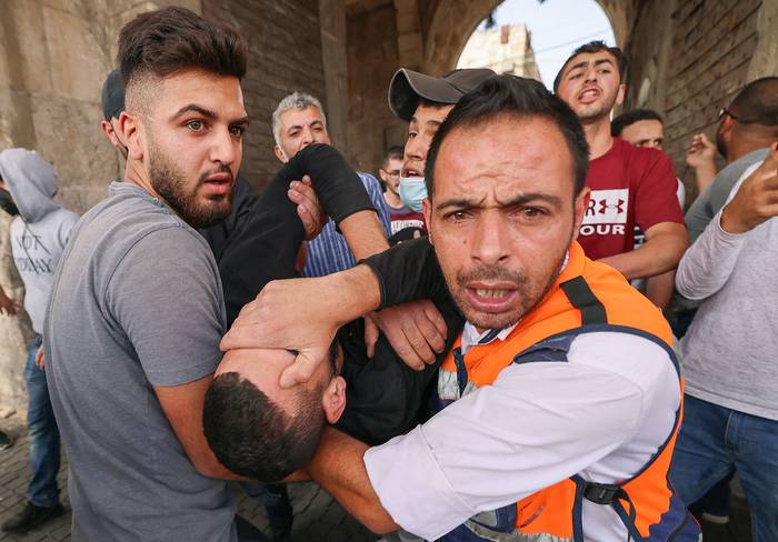 Médicos palestinos evacuan a un manifestante herido en medio de enfrentamientos con las fuerzas de seguridad israelíes, ayer, en la Ciudad Vieja de Jerusalén.
 · Foto: Emmanuel Dunand, AFP