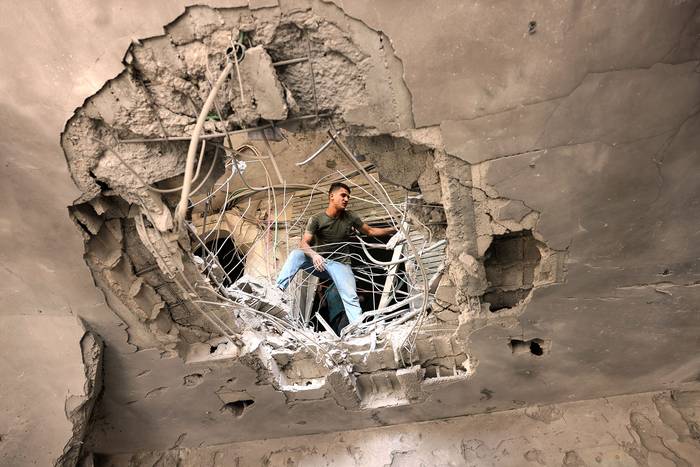 Un palestino revisa los daños causados por un ataque aéreo israelí. en el Banco Nacional Islámico del movimiento palestino Hamas, este jueves, en Khan Yunis, en el sur de la Franja de Gaza.
 · Foto: Said Khatib, AFP