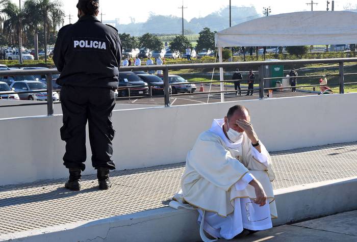 Un sacerdote descansa durante una misa en el estacionamiento del Aeropuerto Internacional Silvio Pettirossi, el 28 de julio, en Luque, cerca de Asunción.
 · Foto: Norberto Duarte, AFP