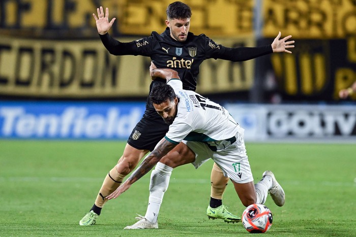 Martín Ferreira, de Racing, y Rodrigo Pérez, de Peñarol, el 9 de marzo, en el estadio Campeón del Siglo. · Foto: Guillermo Legaria, Agencia Gamba