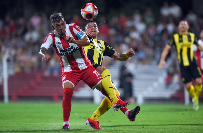 Christian Almeida, de River Plate, y Diego García, de Peñarol, este domindo, en el estadio Federico Saroldi. · Foto: Gianni Schiaffarino