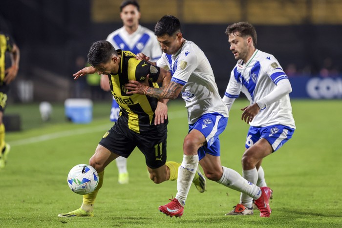 Maximiliano Silvera, de Peñarol, y Agustín Bouzat, y Claudio Baeza de Vélez Sarsfield, el 29 de mayo, en el Campeón del Siglo. · Foto: Rodrigo Viera Amaral