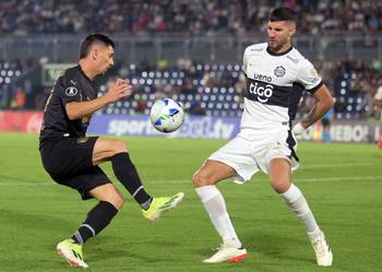 Maximiliano Silvera, de Peñarol, y Lisandro López, de Olimpia, el 23 de abril, en el estadio Defensores del Chaco, en Asunción. · Foto: José Bogado, AFP
