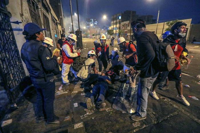Un manifestante herido recibe atención durante los enfrentamientos con la policía, el sábado, en Lima. · Foto: lucas Aguayo, AFP