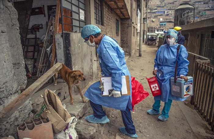 Trabajadores de la salud llegan para inocular a ancianos con dosis de la vacuna Pfizer-BioNTech, este miércoles, en el distrito El Agustino en Lima, Perú. · Foto: Ernesto Benavides, AFP