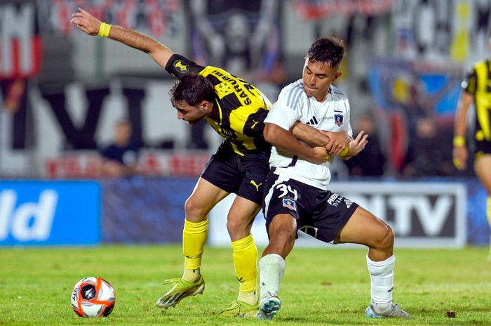 Vicente Pizarro, de Colo-Colo, y Pedro Milans, de Peñarol, el domingo, en el estadio Domingo Burgueño. · Foto: Gianni Schiaffarino