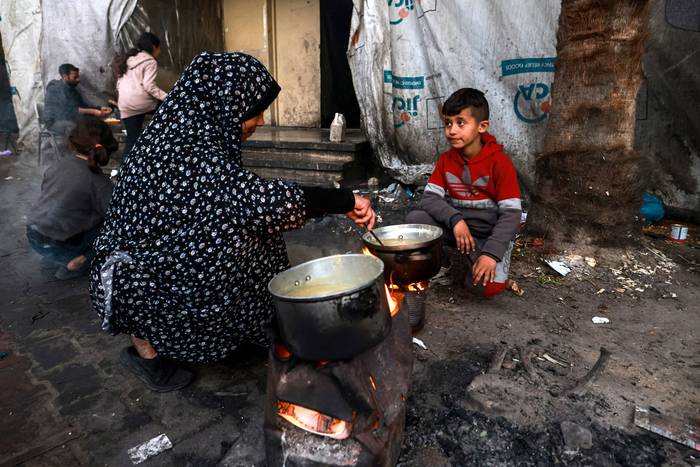 Una mujer palestina prepara una comida "iftar", el segundo día del mes sagrado del Ramadán, el martes 12 de marzo, en un campamento en la Franja de Gaza. · Foto: Mohammed Abed, AFP