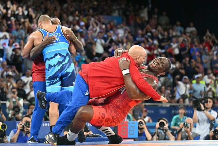 Mijaín López Núñez, de Cuba, festeja junto a su entrenador, luego de vencer a Yasmani Acosta, de Chile, en lucha greco-romana masculina, el 6 agosto en París. · Foto: Punit Paranjpe,  AFP