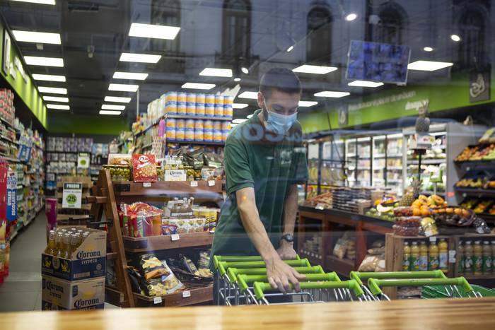 Trabajador de un supermercado, sobre la avenida 18 de Julio de Montevideo (archivo, marzo de 2020). · Foto: .