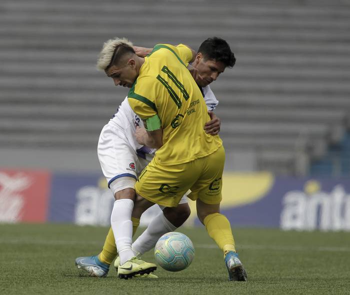 Maximiliano Silvera, de Cerrito, y  Eric Barrios, de Juventud de Las Piedras, en el estadio Charrúa.  · Foto: .