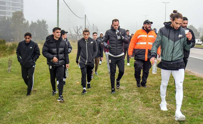 Jugadores de la selección uruguaya caminan, ayer, hasta el Complejo Celeste y cumplen una promesa por su clasificación para el Mundial de Catar 2022. · Foto: Diego Lafalche, EFE