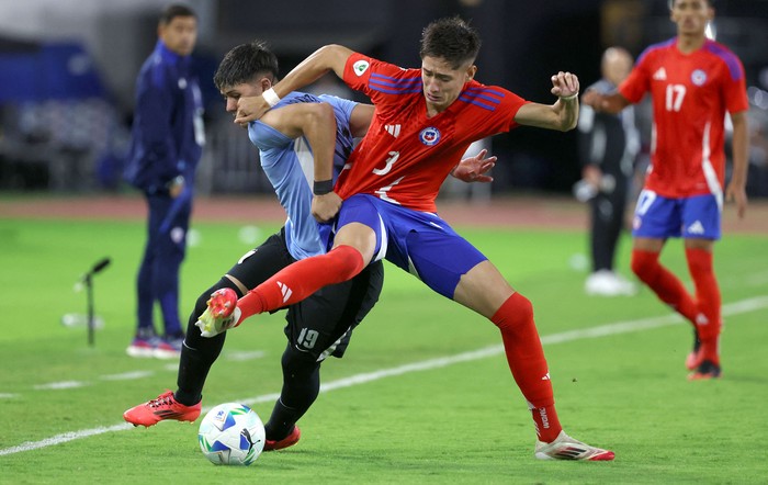 Esteban Crucci, de Uruguay, e Iván Román, de Chile, el 10 de febrero, en el estadio Brígido Iriarte en Caracas. · Foto: Edison Gamez, AFP