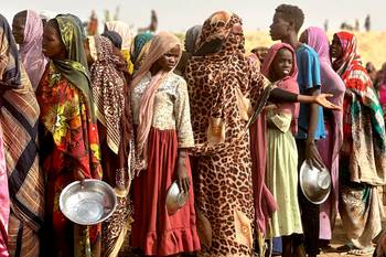 Personas que huyeron del campamento de desplazados internos de Zamzam hacen cola para recibir raciones de comida, el 13 de abril, cerca de la ciudad de Tawila, Sudán. · Foto: AFP