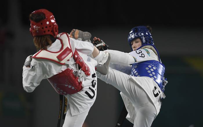 Melina Daniel, de Estados Unidos, y Maria Grippoli, de Uruguay, compiten en taekwondo, en los Juegos Panamericanos Santiago 2023 (21.10.2023). · Foto: Sandro Pereyra, Agencia Gamba
