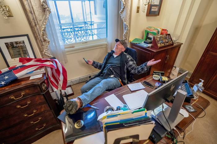 Un partidario de Donald Trump ocupa el escritorio de la presidenta de la Cámara de Representantes, Nancy Pelosi, ayer, en el Capitolio de Estados Unidos, en Washington.
 · Foto: Jim Lo Scalzo, Efe