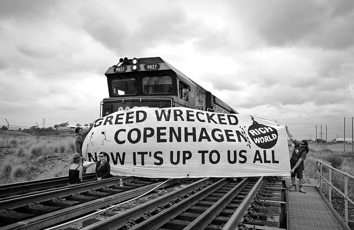 
Manifestantes de la ONG australiana Rising Tide sostienen una pancarta que reza "La  codicia destruyó Copenhague, ahora depende de nosotros" mientras detienen un tren de carbón cerca del puerto de New Castle, Australia. 
 · Foto: Efe, Connor Ashleigh