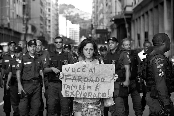 Una manifestante sostiene un cartel de protesta frente a la Policía durante una concentración de miles de personas en Amaral Peixoto, la calle principal de la ciudad de Niterói, vecina a Río de Janeiro.  · Foto: Marcelo Sayão, Efe