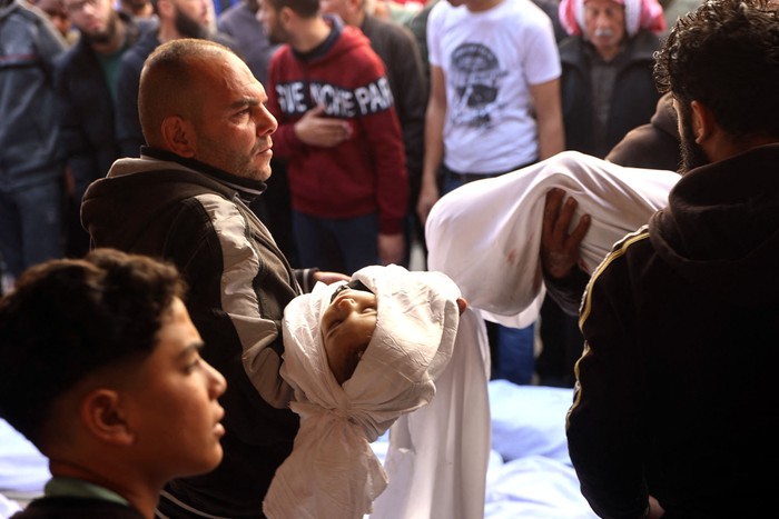 Un palestino carga el cuerpo de un niño que murió en un ataque aéreo israelí nocturno contra la Franja de Gaza, el 18 de marzo, en el hospital árabe Al-Ahli, en la ciudad de Gaza. · Foto: Omar Al-Qattaa, AFP