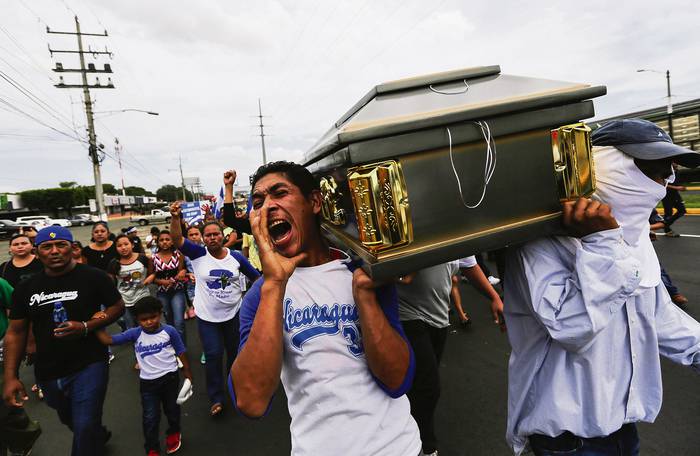Amigos y familiares llevan el ataúd que contiene el cuerpo del estudiante Gerald Velázquez, muerto a tiros durante enfrentamientos con la Policía antidisturbios en una iglesia cerca de la Universidad Nacional Autónoma de Nicaragua (UNAN) en Managua. AFP · Foto: Inti Ocon