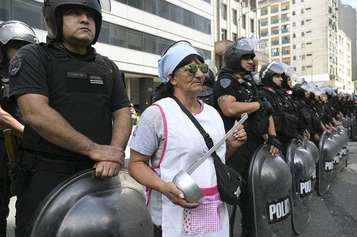 Manifestante y policías antidistubios afuera del ministerio de Capital Humano, en Buenos Aires. · Foto: Juan Mabromata,  AFP