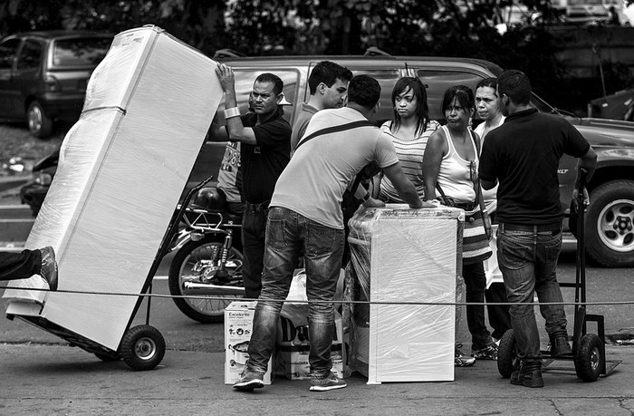 Un grupo de personas transporta electrodomésticos luego de comprarlos en una de las tiendas de la cadena Daka, ayer en Caracas, Venezuela.  · Foto:  Miguel Gutiérrez, Efe