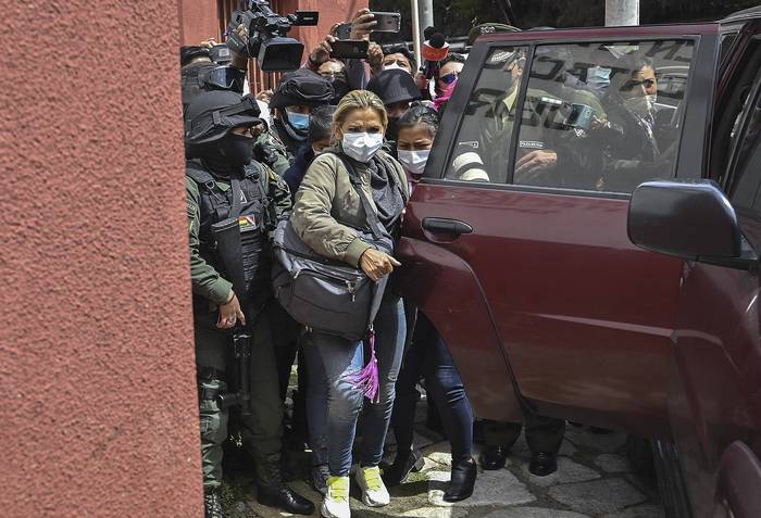 La ex presidenta de facto boliviana Jeanine Añez conducida por miembros de la Fuerza Especial Contra el Crimen (FELCC) al penal de Obrajes en La Paz, luego de que un juez ordenara cuatro meses de prisión preventiva.  · Foto: Aizar Raldes, AFP