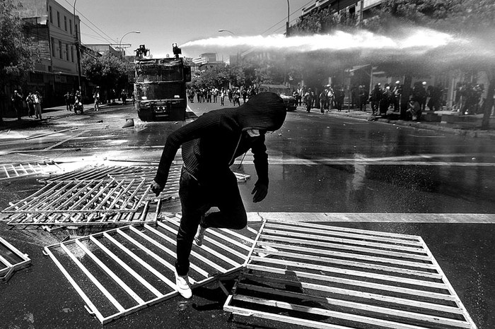 Manifestantes se enfrentan con la Policia, ayer, durante la marcha convocada por la Confederacion de Estudiantes de Chile (Confech) por las calles de Valparaiso,
con la finalidad de presionar a los parlamentarios para que no aprueben el Presupuesto 2012 por no tener en cuenta las demandas estudiantiles. · Foto: Efe, Mario Ruiz