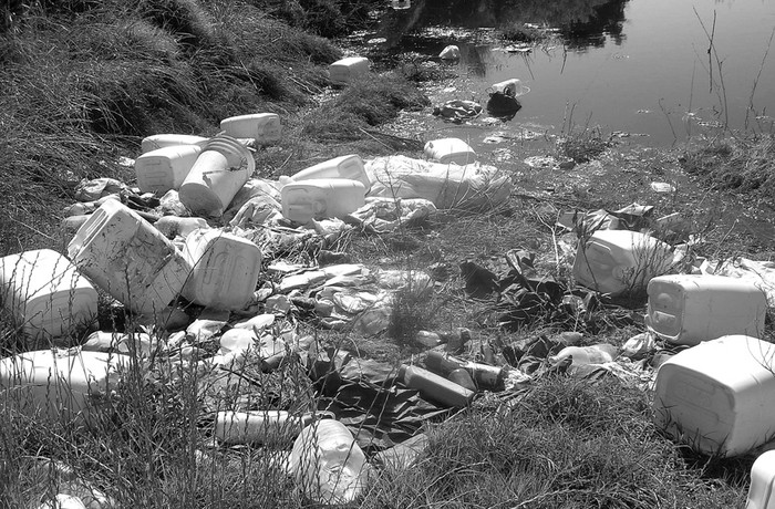 Envases de glifosato, entre otros abandonados en una cantera próxima a la localidad de Menafra, en el departamento de Río Negro.  · Foto: Marcelo Fagundez