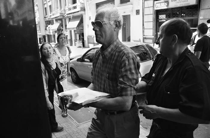 El teniente aviador Enrique Ribero, ayer, cuando era conducido por policias a la sede judicial. · Foto: Pablo Nogueira