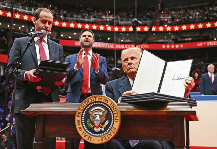 Donald Trump sostiene una orden ejecutiva que acaba de firmar durante el desfile inaugural dentro del Capital One Arena, el 20 de enero, en Washington. · Foto: Jim Watson, AFP