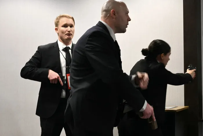 Agentes desenfundan sus armas tras escucharse fuertes disparos durante la cena de corresponsales de la Casa Blanca en el hotel Washington Hilton de Washington, el 25 de abril. · Foto: Mandel Ngan, AFP