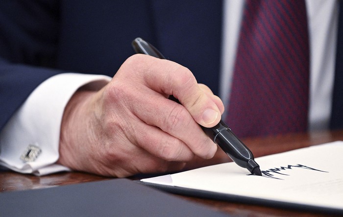 Donald Trump firma una orden ejecutiva, este jueves, en la Oficina Oval de la Casa Blanca. · Foto: Roberto Schmidt, AFP