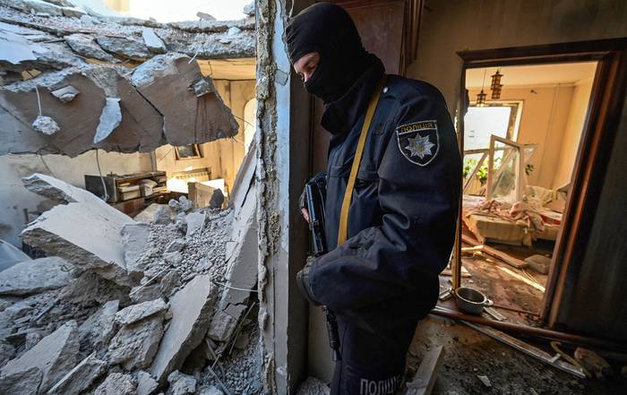 Un policía inspecciona un apartamento destruido por un cohete derribado, ayer, en Kiev. · Foto: Genya Savilov, AFP 